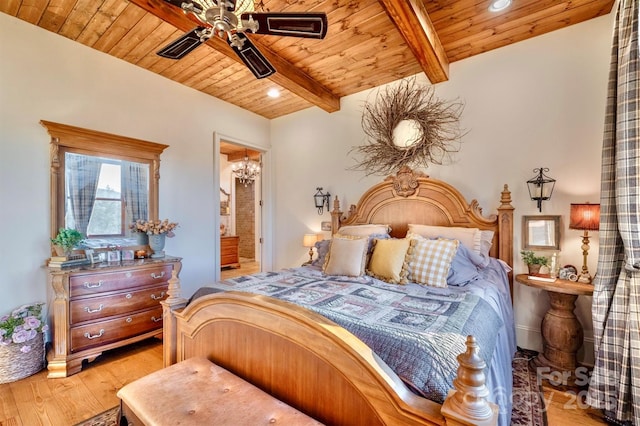 bedroom featuring beamed ceiling, recessed lighting, light wood-style flooring, wooden ceiling, and ensuite bathroom