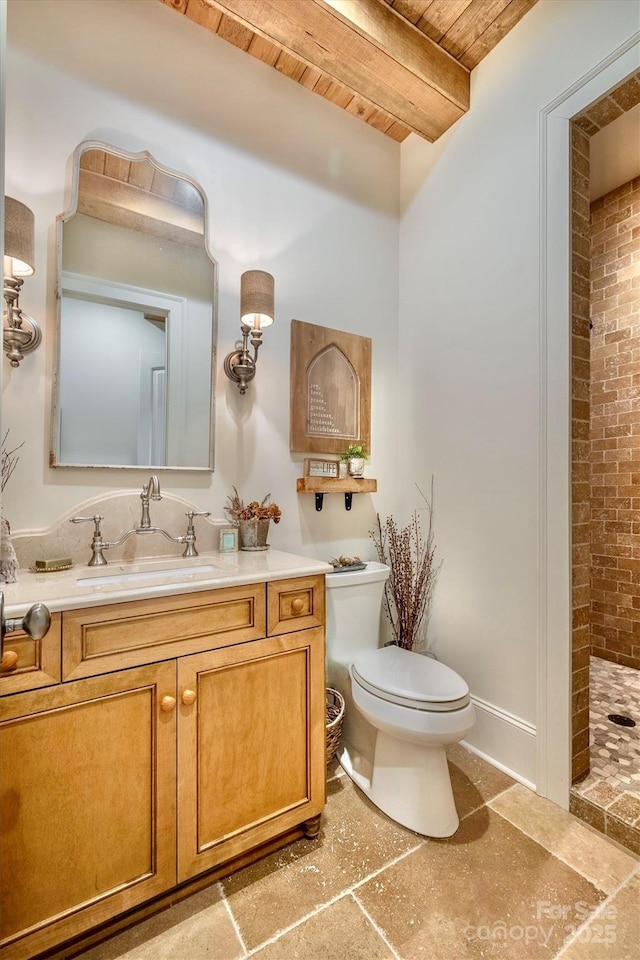 bathroom with beam ceiling, toilet, tiled shower, wood ceiling, and vanity