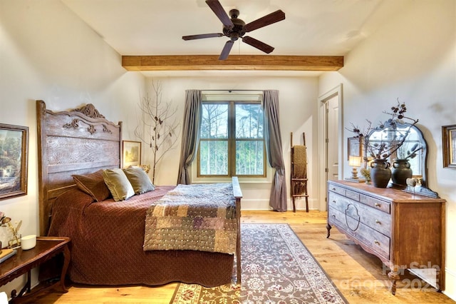 bedroom featuring beam ceiling, light wood-style floors, and ceiling fan