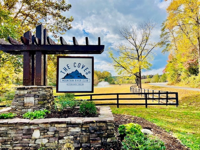 community / neighborhood sign featuring fence