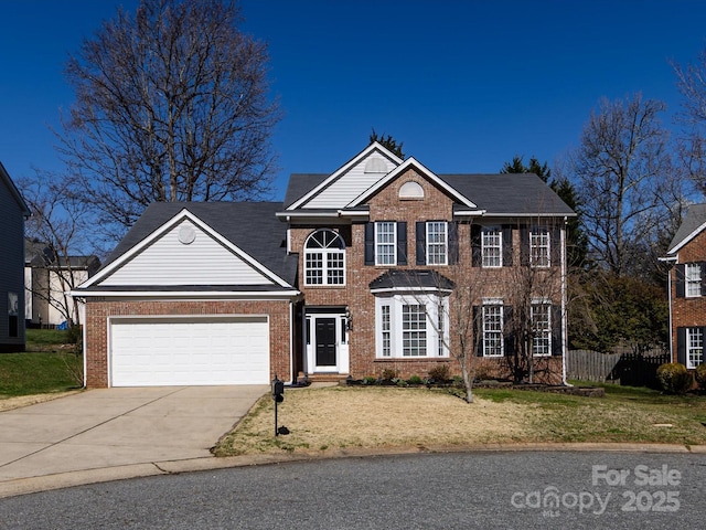 view of front facade with fence, concrete driveway, a front yard, an attached garage, and brick siding