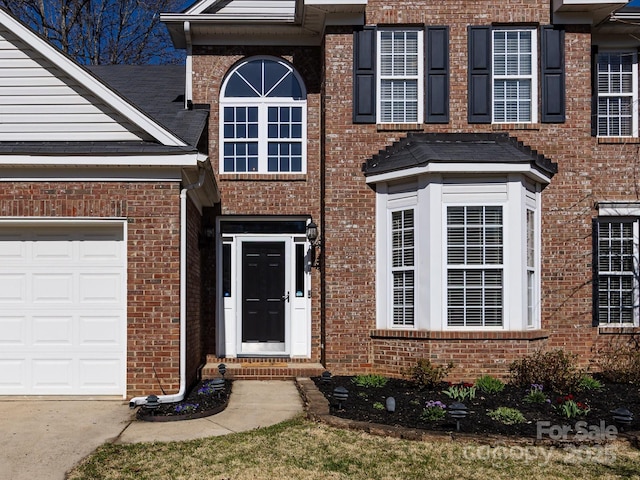 entrance to property with brick siding and a garage