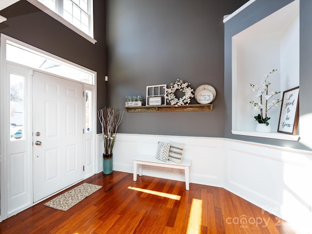 foyer entrance with wainscoting and wood finished floors