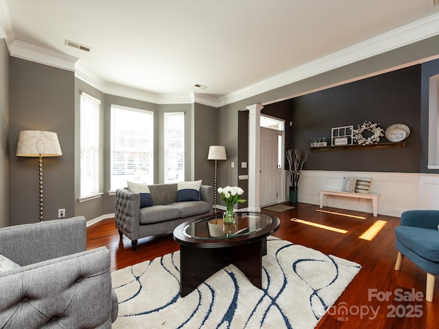 living room featuring crown molding, decorative columns, wood finished floors, and visible vents