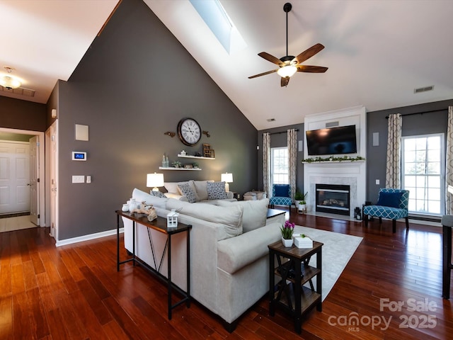 living room with visible vents, a fireplace with flush hearth, high vaulted ceiling, and wood finished floors