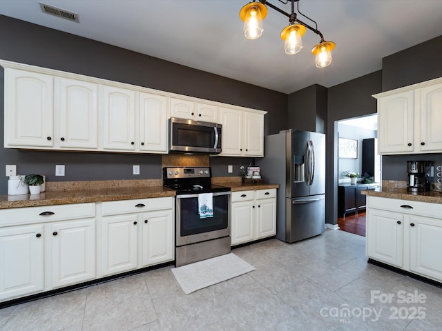 kitchen featuring white cabinets, visible vents, appliances with stainless steel finishes, and pendant lighting