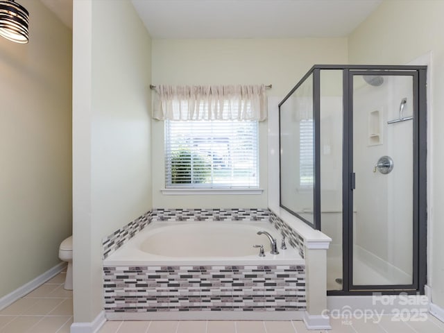 bathroom featuring tile patterned flooring, toilet, a bath, and a stall shower