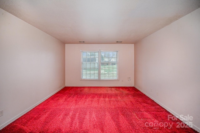 spare room with baseboards, carpet floors, and visible vents