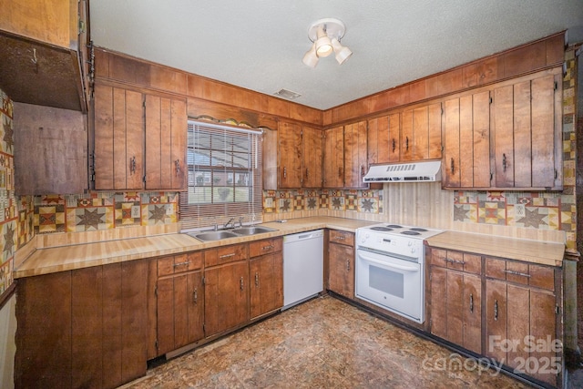 kitchen featuring a sink, white appliances, range hood, and light countertops