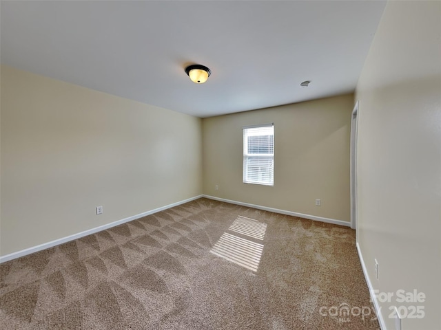 spare room with baseboards and carpet