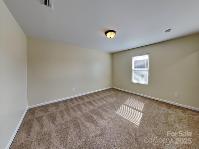 unfurnished room featuring visible vents, baseboards, and carpet