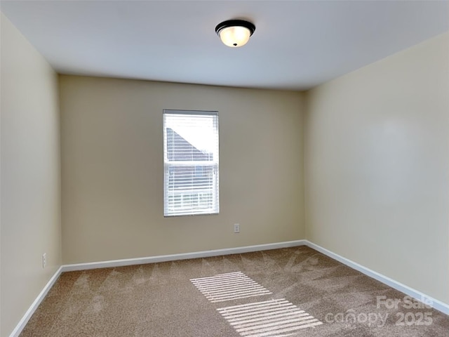 carpeted spare room featuring baseboards