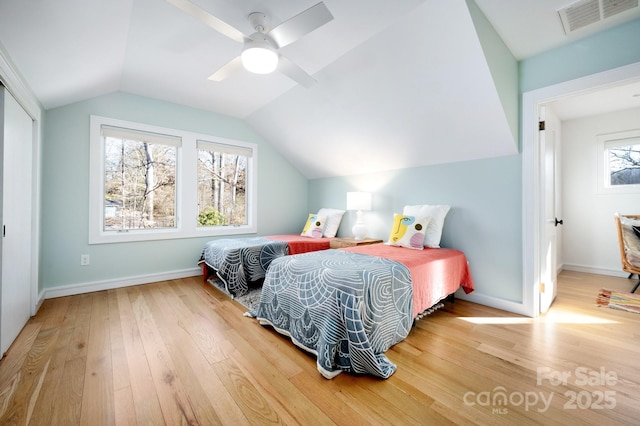 bedroom with baseboards, visible vents, wood-type flooring, and lofted ceiling