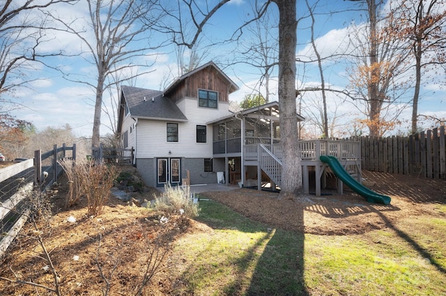 back of property with stairway, a fenced backyard, a sunroom, and a wooden deck