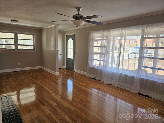 foyer featuring wood finished floors, visible vents, baseboards, ceiling fan, and ornamental molding