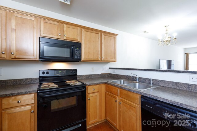 kitchen with black appliances, a notable chandelier, dark countertops, and a sink