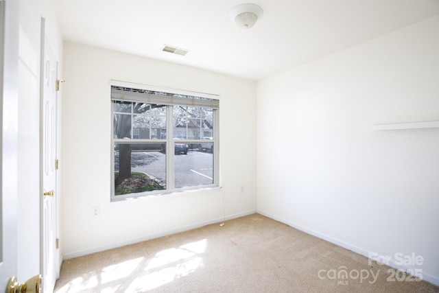 carpeted empty room with visible vents and baseboards