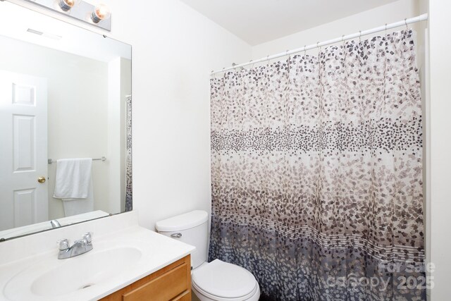 bathroom featuring visible vents, curtained shower, toilet, and vanity