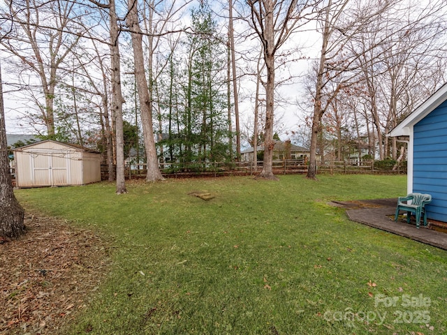 view of yard featuring an outdoor structure, a storage unit, and fence