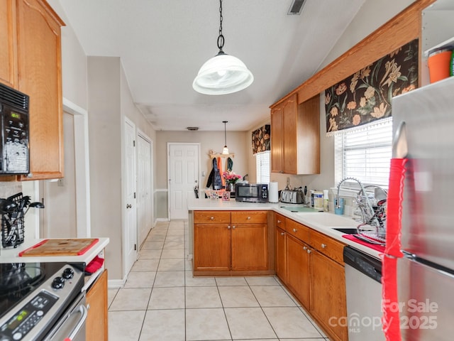 kitchen with pendant lighting, light countertops, appliances with stainless steel finishes, light tile patterned flooring, and a sink