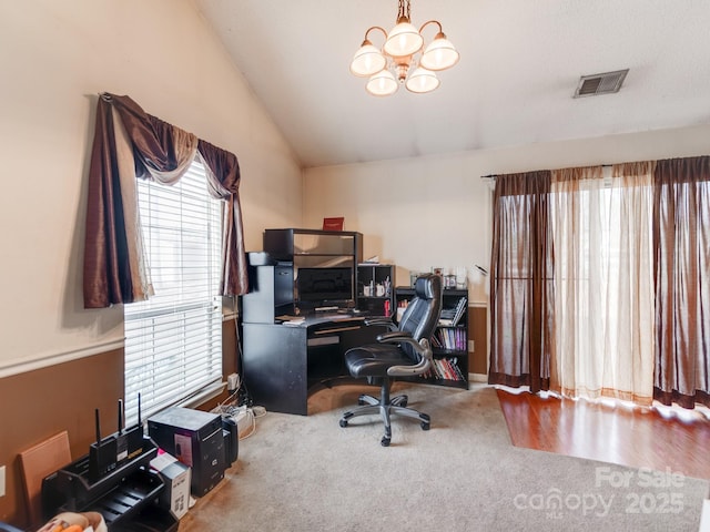 office space featuring visible vents, an inviting chandelier, carpet flooring, and lofted ceiling