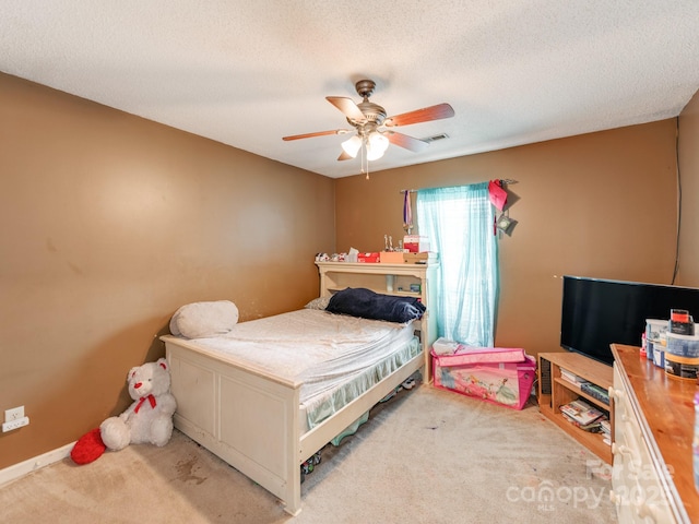 bedroom featuring ceiling fan, carpet flooring, and a textured ceiling