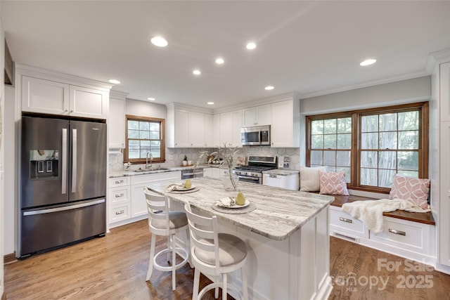 6688 Pine Forest Dr, York, SC 29745 - kitchen featuring stainless steel appliances, a sink, ornamental molding, white cabinets, and light stone counters