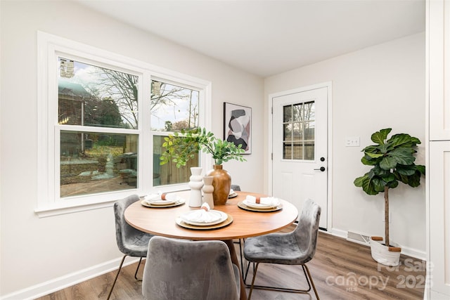 dining area featuring a wealth of natural light, baseboards, and wood finished floors