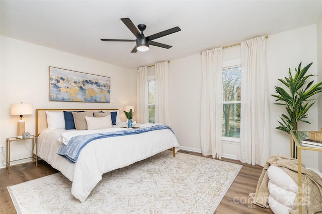 bedroom with baseboards, ceiling fan, and wood finished floors