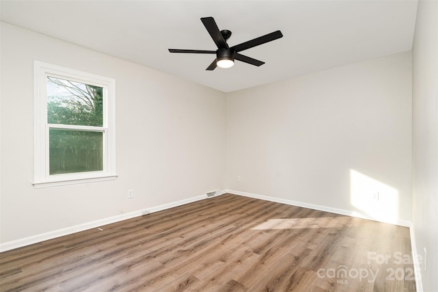 spare room with visible vents, baseboards, wood finished floors, and a ceiling fan