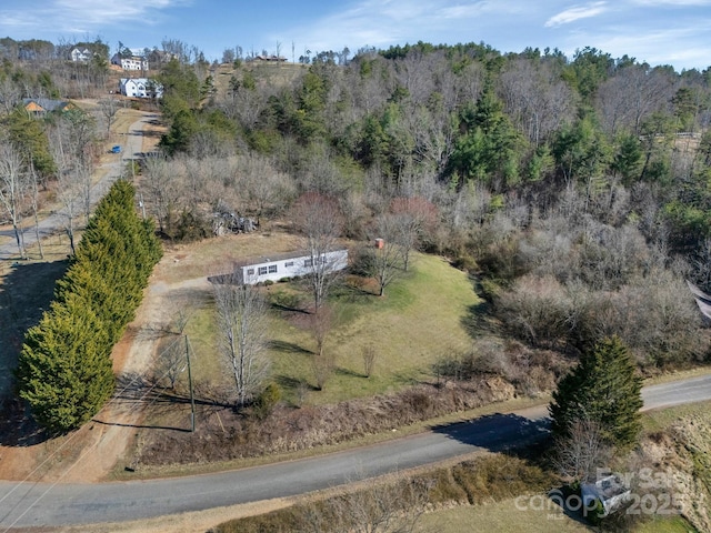 drone / aerial view featuring a view of trees