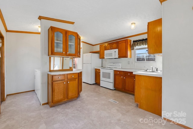 kitchen with visible vents, ornamental molding, a sink, white appliances, and light countertops