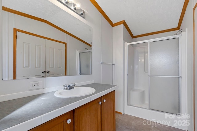 full bath with vanity, ornamental molding, and a shower stall