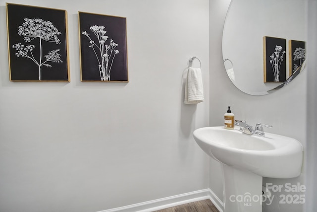 bathroom featuring wood finished floors, baseboards, and a sink