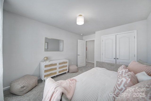 carpeted bedroom featuring a closet and baseboards