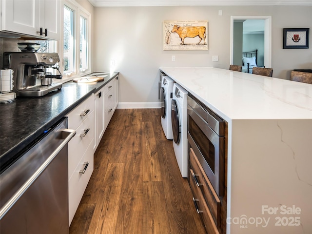 kitchen featuring washer / clothes dryer, a peninsula, stainless steel appliances, and dark wood-type flooring