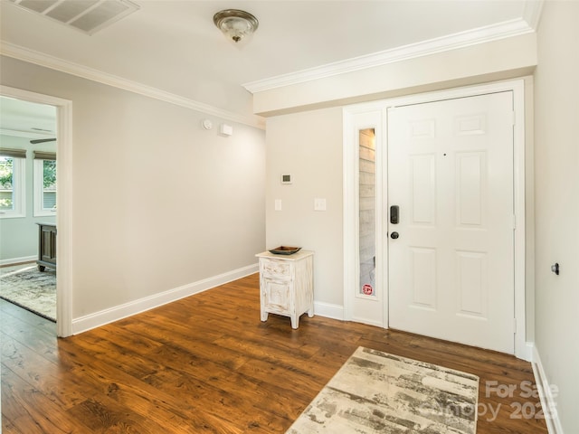 entrance foyer featuring dark wood finished floors, baseboards, visible vents, and ornamental molding