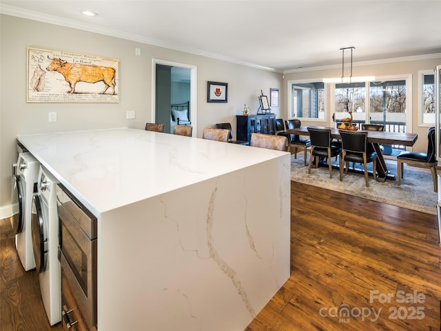 kitchen with dark wood-style floors, crown molding, and light stone counters