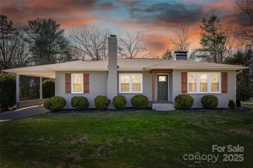 3131 Jones Wade Rd, Hudson, NC 28638 - view of front of house with a chimney, brick siding, a carport, and a lawn