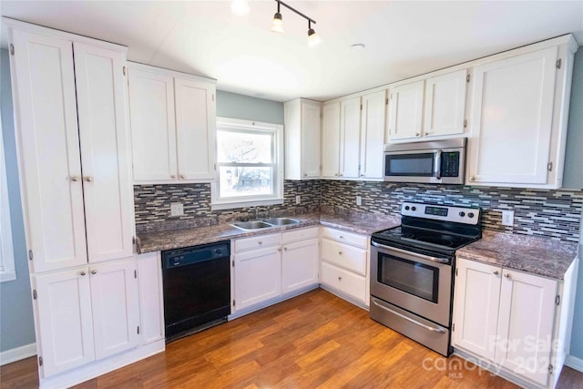 kitchen featuring light wood-style flooring, white cabinetry, stainless steel appliances, and a sink