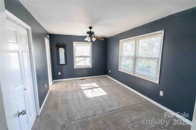 unfurnished bedroom with ceiling fan, baseboards, and carpet floors