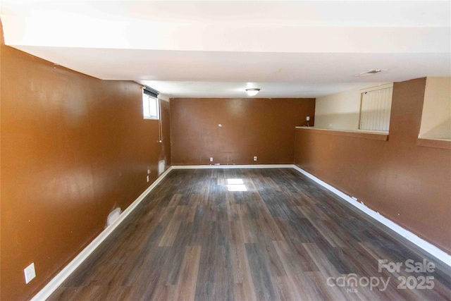 below grade area with visible vents, baseboards, and wood finished floors