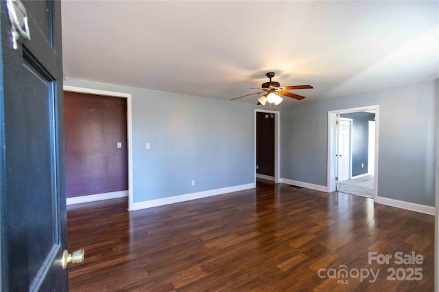 spare room featuring ceiling fan, baseboards, and wood finished floors