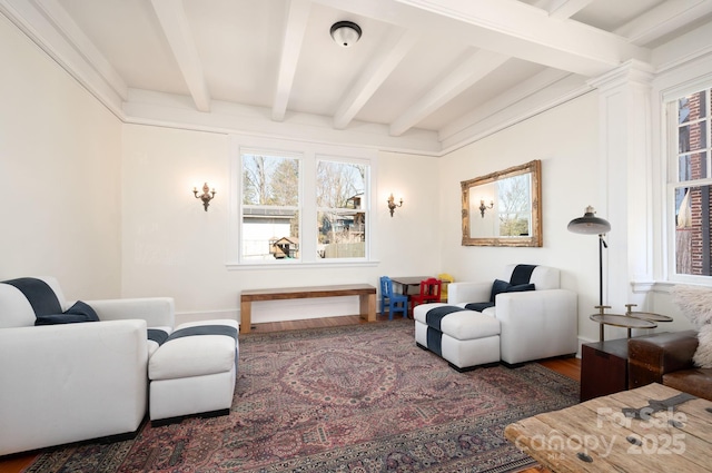 living area featuring beamed ceiling and wood finished floors
