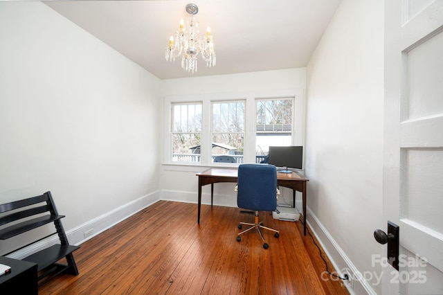 home office featuring baseboards, an inviting chandelier, and hardwood / wood-style floors