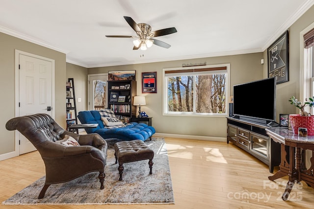 living area featuring light wood-style flooring, baseboards, ceiling fan, and ornamental molding