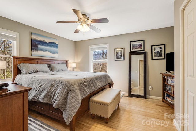 bedroom featuring a ceiling fan, light wood-style floors, and baseboards