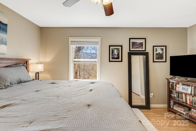 bedroom with ceiling fan, baseboards, and wood finished floors