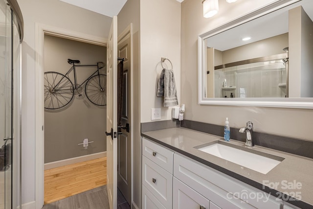 bathroom featuring vanity, baseboards, and wood finished floors