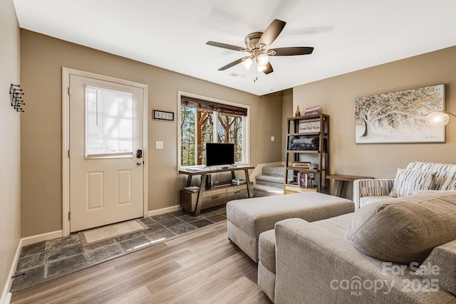 living room featuring baseboards, wood finished floors, visible vents, and ceiling fan